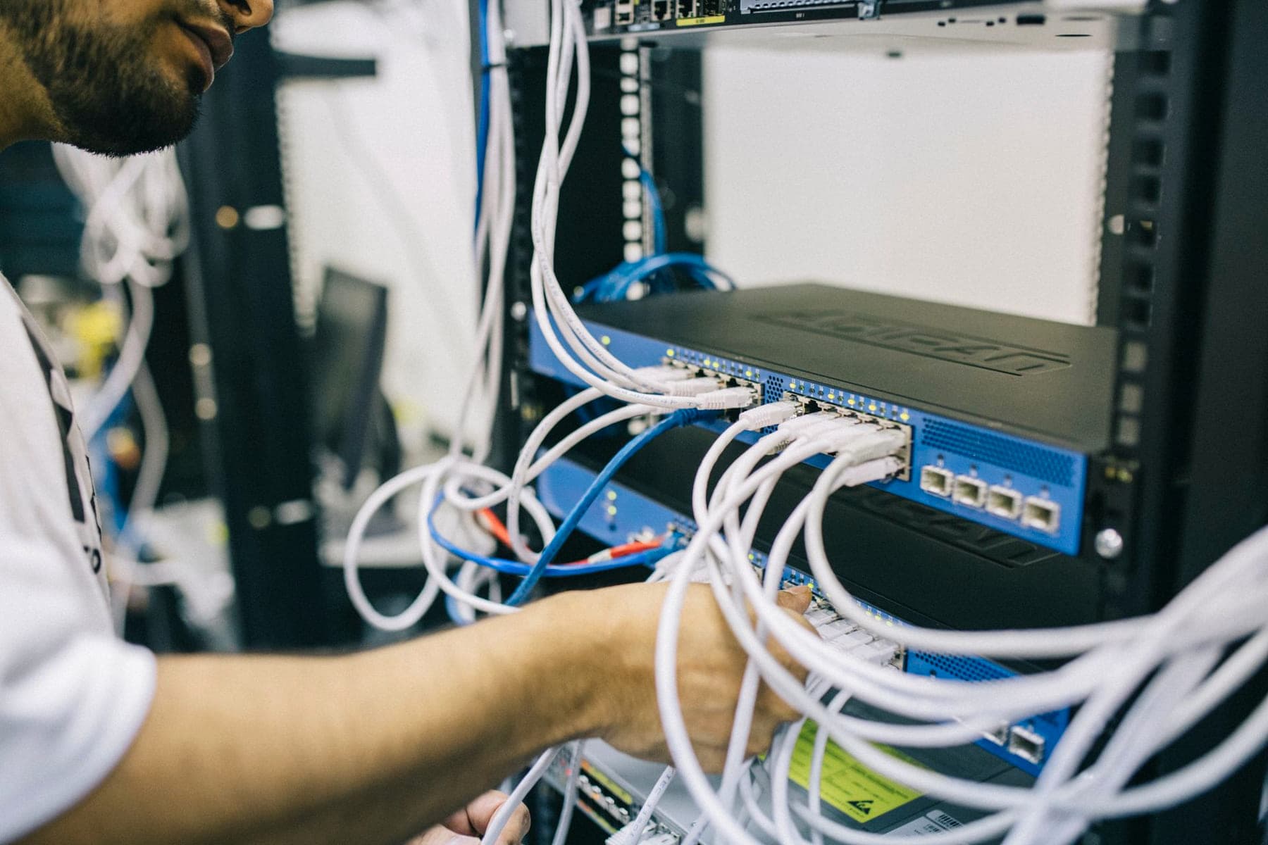 Engineer patching a network cabinet