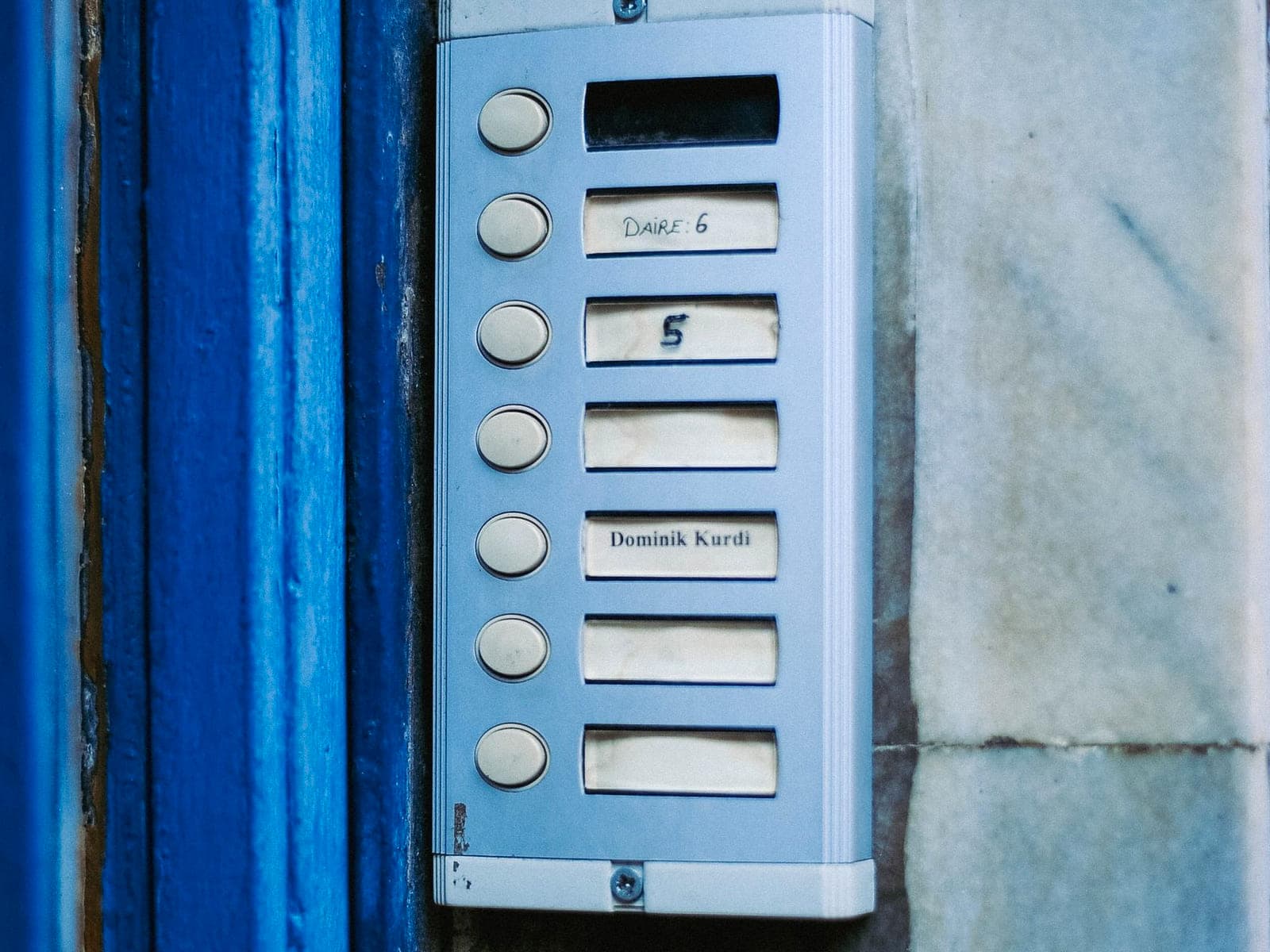Multi-button door entry panel mounted at the entrance of a residential building